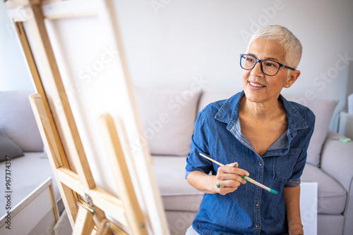 Schilderij op canvas Mature Woman Joyfully Painting in Casual Home Setting
