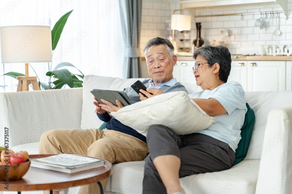 Senior Asian couple grandparents using a smart phone together on sofa at home.Senior asian elderly couple enjoy retirement life at home.happiness retirement,Healthcare,Asian happy family concept Senior Asian couple grandparents using a smart phone together on sofa at home.Senior asian elderly couple enjoy retirement life at home.happiness retirement,Healthcare,Asian happy family concept