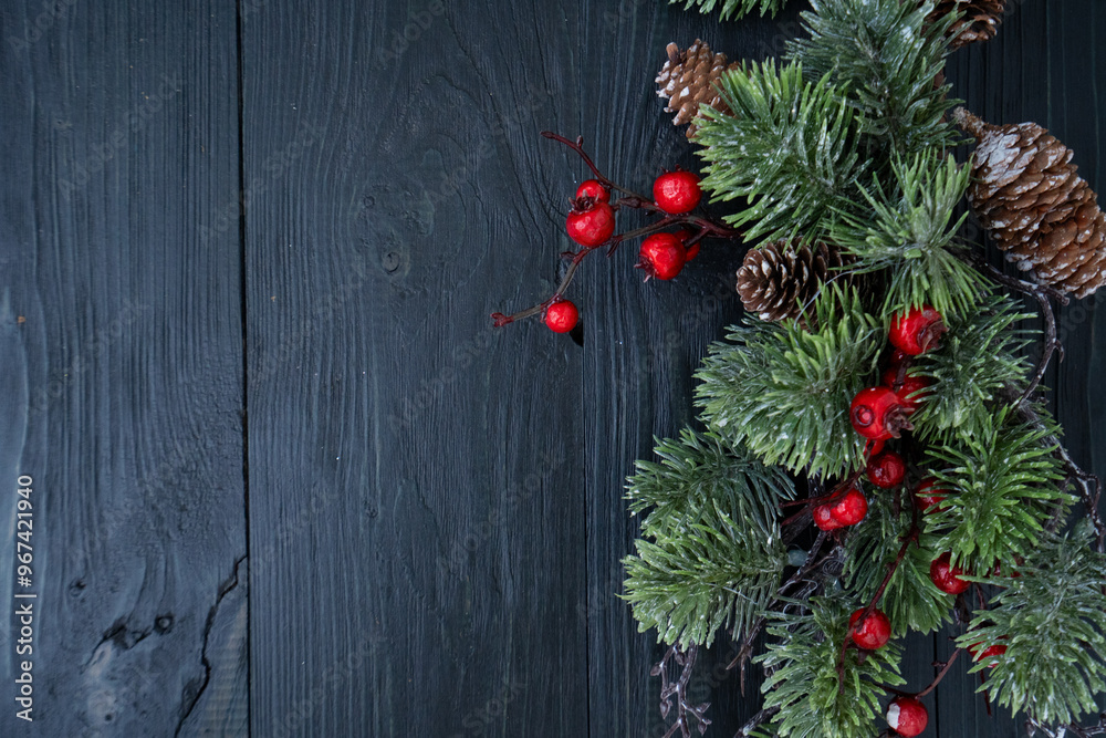 Beautiful holiday decoration featuring evergreen branches, berries, and pine cones on a rustic wood background. Beautiful holiday decoration featuring evergreen branches, berries, and pine cones on a rustic wood background.