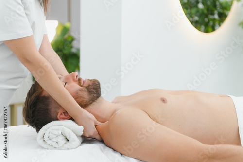 Handsome middle-aged man enjoying relaxing spa massage with oils photo