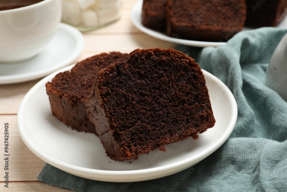 Slices of delicious chocolate sponge cake on white wooden table, closeup Slices of delicious chocolate sponge cake on white wooden table, closeup