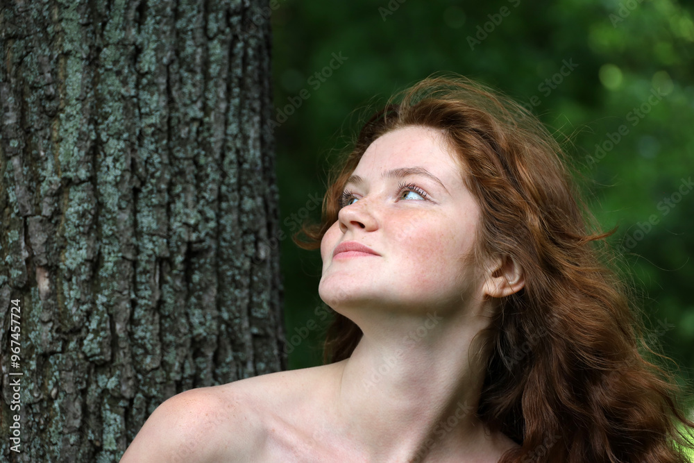 Portrait of smiling ginger girl with long red hair and freckles in park. Young sensual model with naked shoulders, natural female beauty Portrait of smiling ginger girl with long red hair and freckles in park. Young sensual model with naked shoulders, natural female beauty