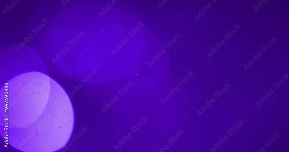 Animation of glowing light spots moving over purple background