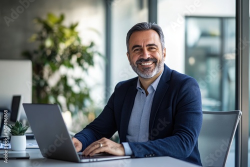 Portrait of a smiling businessman sitting at a desk with a laptop in a modern office ,generative ai 