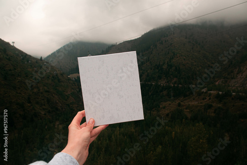 Female hand holding empty canvas. Autumn mountain landscape with mountains on the background. Kazakhstan, Almaty, Medeo photo