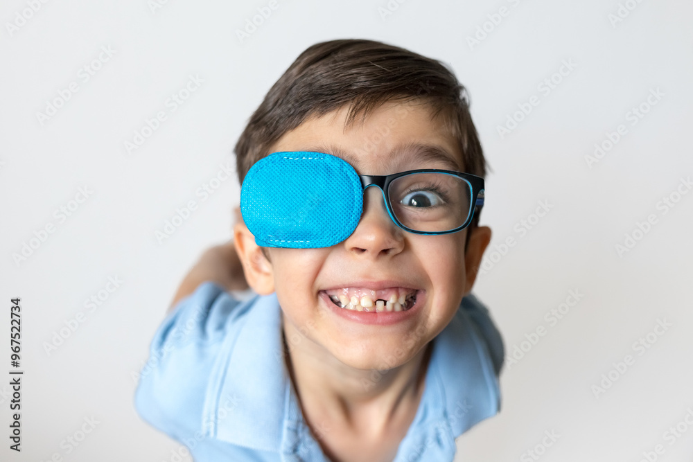 Boy in glasses with eye patch. Occluder, lazyeye, amblyopia, strabismus. Vision testing concept. Reviewing eyesight Boy in glasses with eye patch. Occluder, lazyeye, amblyopia, strabismus. Vision testing concept. Reviewing eyesight