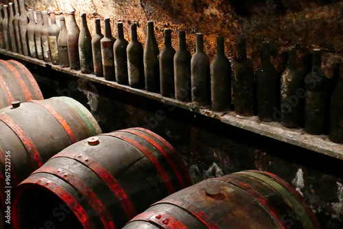 Old barrels and wine bottles with noble mold on them in a wine cellar in Etyek, Hungary photo