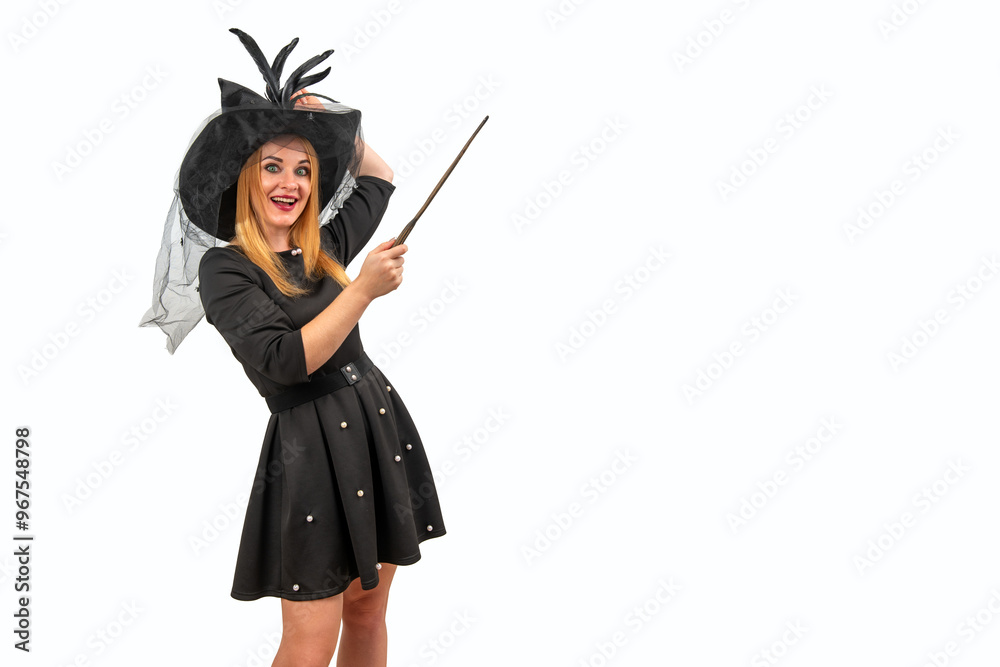 Young woman dressed as a witch for Halloween is casting a spell with her magic wand