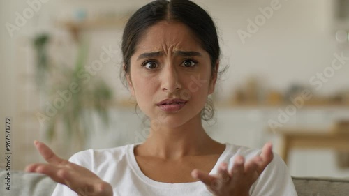 Portrait indoors shocked wonder amazed woman stunned puzzled confused Indian girl anxiety worried female Arabian lady at home looking at camera loan mortgage health problem shock open mouth big eyes