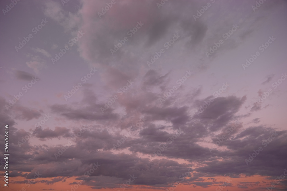 Evening sky with gray clouds in soft twilight lilac light illuminates the clouds creating a stunning contrast. A sense of peace, tranquility and contemplation...
