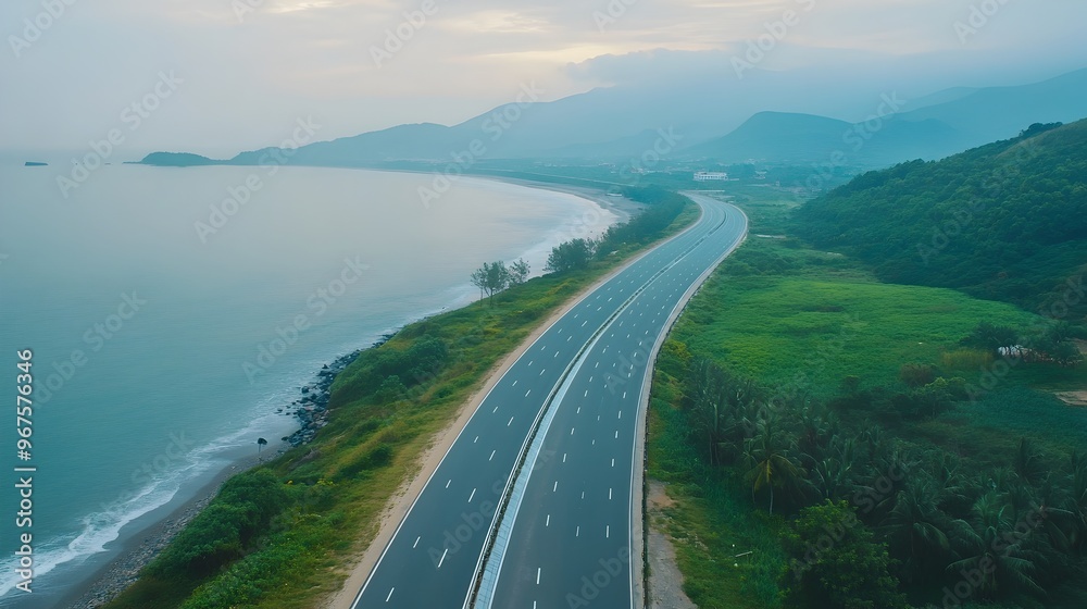 Obraz premium Majestic Coastal Highway Winding Through Lush Green Landscapes and Towering Mountains