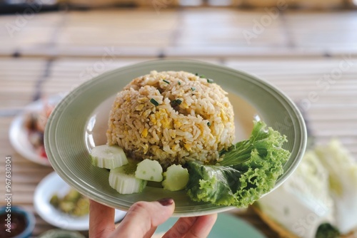 Fried rice served in a bowl with fresh vegetables on the side photo