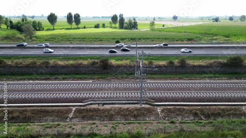 Europe, Italy , Milan 09,14,2024  - Frecciarossa Trenitalia  Hight speed 300km h train railway  view from the drone - the faster way to travel in Italy from Milan to Rome. A1 motorway , cars and train photo