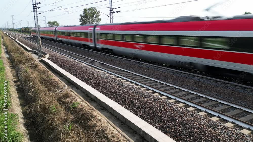 Europe, Italy , Milan 09,14,2024  - Frecciarossa Trenitalia  Hight speed 300km h train railway  view from the drone - the faster way to travel in Italy from Milan to Rome. A1 motorway , cars and train