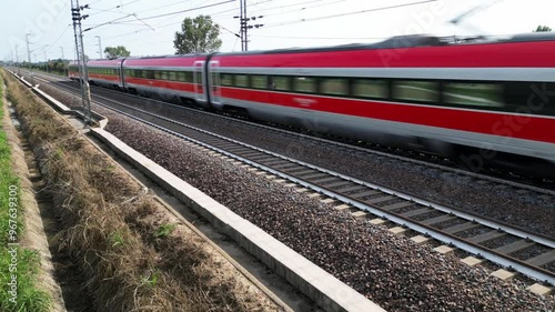 Europe, Italy , Milan 09,14,2024  - Frecciarossa Trenitalia  Hight speed 300km h train railway  view from the drone - the faster way to travel in Italy from Milan to Rome. A1 motorway , cars and train photo