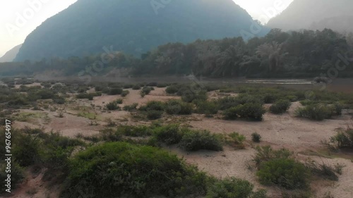 Aerial view of a serene river with fishing boats and lush vegetation at sunset, Muang Ngoy, Laos. photo