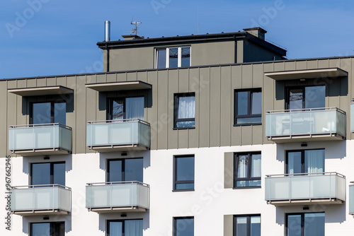 Obraz na płótnie White and beige facade of a newly built apartment block. Clear blue sky above the building. Photo taken on a sunny day w salonie