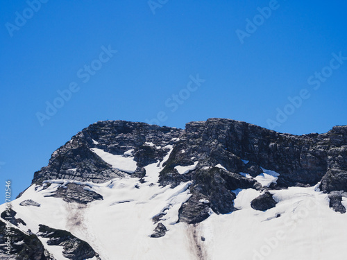 Majestic mountain peaks capped with snow and washed by clouds create a breathtaking wilderness landscape photo