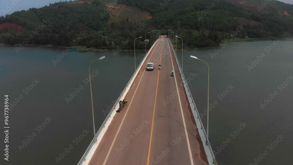 Aerial view of a scenic bridge over a tranquil lake with motorcycle traffic, Da Nang, Vietnam. Aerial view of a scenic bridge over a tranquil lake with motorcycle traffic, Da Nang, Vietnam.