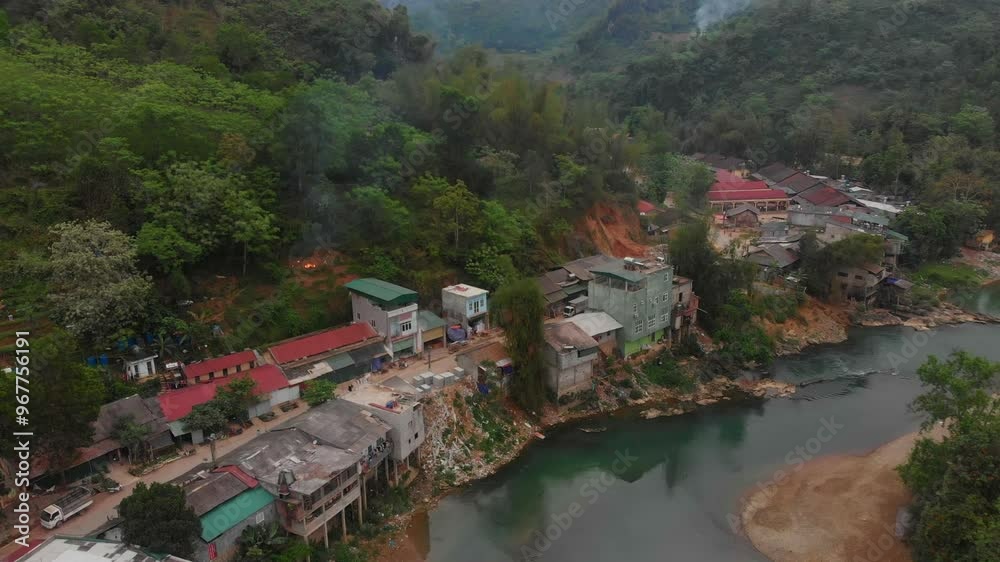 Aerial view of a beautiful village nestled among tranquil mountains and a winding river, Niem Son, Cao Bang, Vietnam. Aerial view of a beautiful village nestled among tranquil mountains and a winding river, Niem Son, Cao Bang, Vietnam.