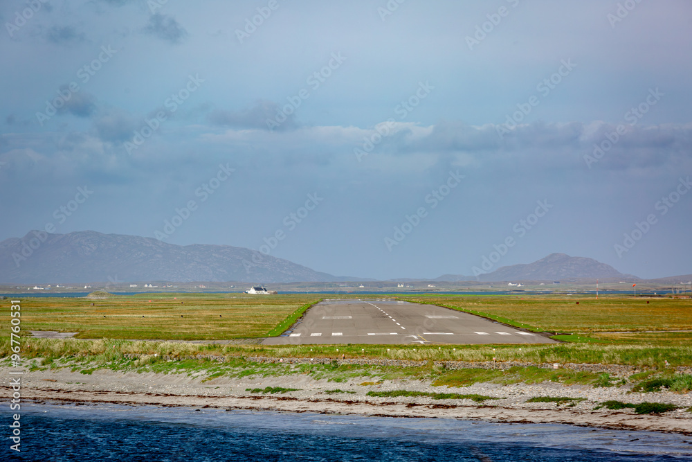 Fototapeta premium View of Benbecula airport runway formally known as RAF Benbecula on a summers day from across the bay
