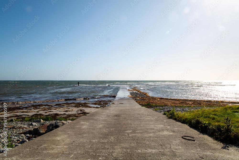 Boat launch ramp on jetty beach in Benbecula, Image shows a long concrete slip road going into the Atlantic ocean Boat launch ramp on jetty beach in Benbecula, Image shows a long concrete slip road going into the Atlantic ocean