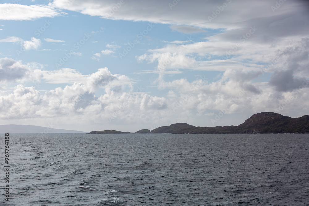View of Scottish mainland from a ship, Image shows beautiful landscape coastal views of the mainland from a ship following the coastline image shows calm seas with heavy cloud and hilly terrain View of Scottish mainland from a ship, Image shows beautiful landscape coastal views of the mainland from a ship following the coastline image shows calm seas with heavy cloud and hilly terrain
