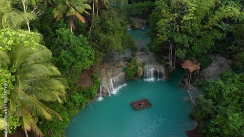 Aerial view of breathtaking Cambugahay Falls with a bamboo raft surrounded by lush tropical forest at sunrise, Lazi, Philippines. photo