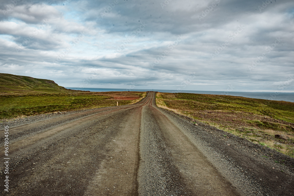 Solitary Journey Along an Unpaved Rural Road Under Cloudy Sky Solitary Journey Along an Unpaved Rural Road Under Cloudy Sky
