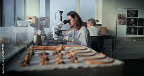 Photos Female scientist analyzes sample of fossil remains under microscope