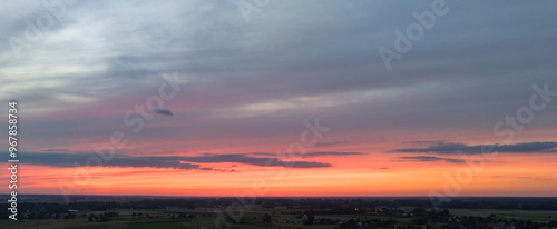 Panoramic view of an orange sky at sunset, with vibrant hues and a dramatic evening sky.