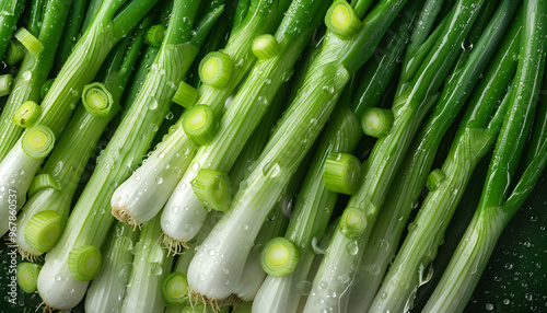 Fresh green spring onions with water drops as background, top view