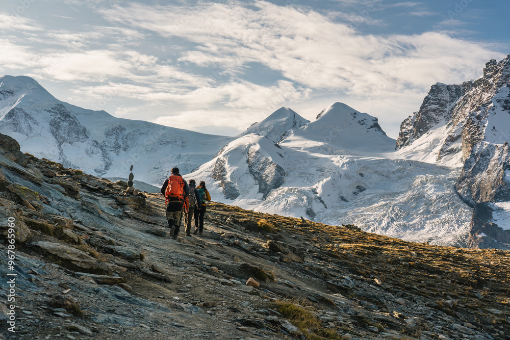 Group of backpacker hiking on alpine summit at Switzerland Group of backpacker hiking on alpine summit at Switzerland