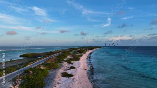 Aerial view of a beautiful tropical island with kitesurfers on a serene beach and tranquil ocean, Caribbean.