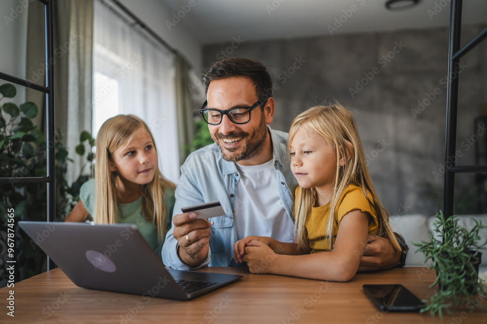 Obraz premium Father and daughters have online shopping on laptop with credit card