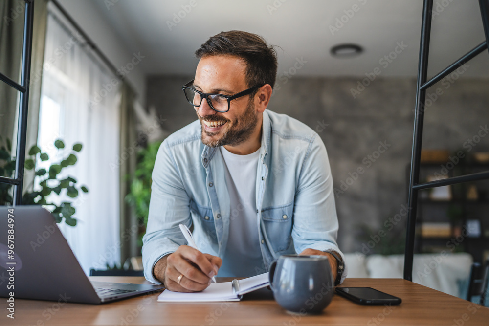 Adult man work from home office with laptop and notebook on the desk Adult man work from home office with laptop and notebook on the desk