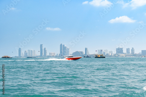 Speedboat sailing on the blue tropical sea on the background of Pattaya cityscape view and clear sky morning day at Koh Larn island. Speed boat running on the bay, Panorama ocean, Thailand, Vacation.