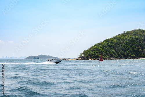 Landscape of island and tropical beach morning day at Koh Larn island on blue sea and blue clear sky background. Pattaya, Thailand. Wave, Speed boat, Ferry ship, Seascape, Vacation, Summer, Holiday.