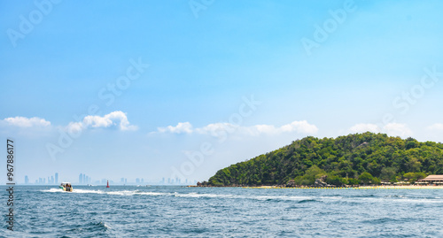 Landscape of island and tropical beach morning day at Koh Larn island on blue sea and blue clear sky background. Pattaya, Thailand. Wave, Speed boat, Ferry ship, Seascape, Vacation, Summer, Holiday.