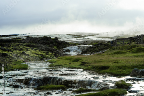 Geothermal Hot Springs in Lush Green Icelandic Landscape with Rising Steam