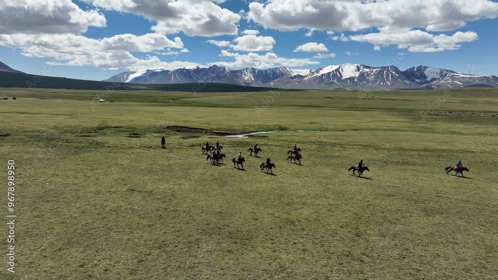Aerial view of breathtaking Altai Mountains with horseback riders in a serene valley, Western Mongolia. Aerial view of breathtaking Altai Mountains with horseback riders in a serene valley, Western Mongolia.