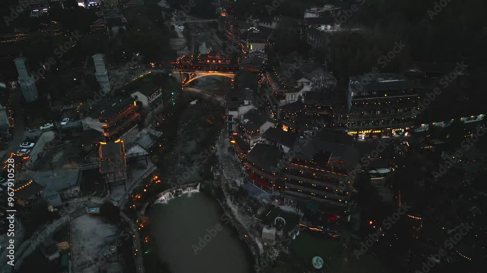 Aerial view of beautiful night cityscape with illuminated buildings and a river, Furong Ancient Town, China. Aerial view of beautiful night cityscape with illuminated buildings and a river, Furong Ancient Town, China.