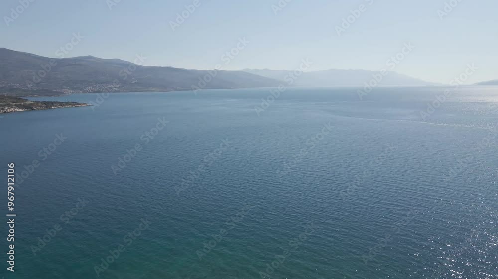 Aerial view of beautiful coastline with tranquil sea and distant mountains, Novi Vinodolski, Croatia.
