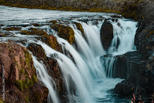 Serene Waterfall in Lush Green Landscape with Mossy Rocks