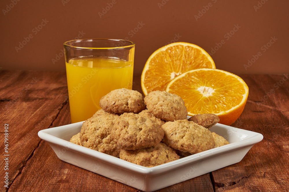 Homemade orange-flavored cookies accompanied by a glass of fresh orange juice Homemade orange-flavored cookies accompanied by a glass of fresh orange juice