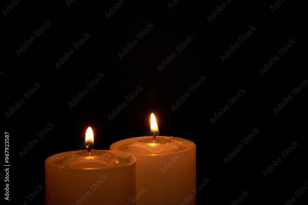 Candles burning against a black background illuminate a hope of faith Candles burning against a black background illuminate a hope of faith