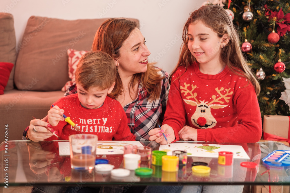 Fototapeta premium Mother of family sharing moments of fun with her children next to the Christmas tree.