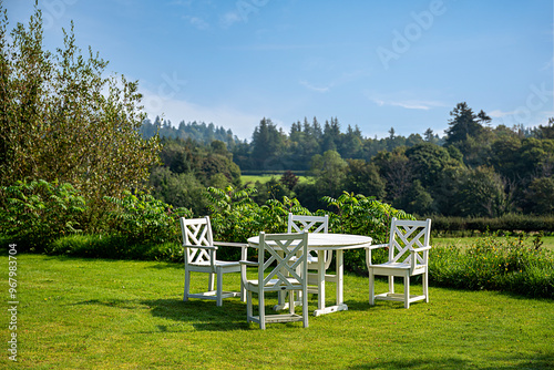 Landscape photography of white garden furniture set, table and chairs, rural scene, countryside, village, farm, forest and pasture; Scotland; UK