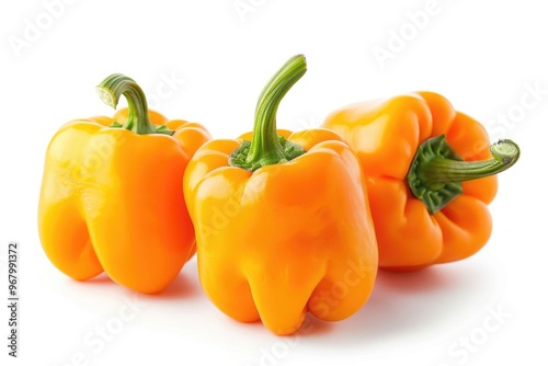 Fresh orange bell peppers arranged on a white background