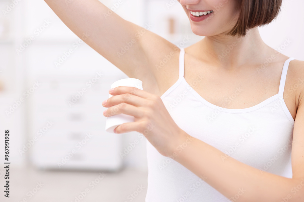 Smiling woman applying solid deodorant at home, closeup Smiling woman applying solid deodorant at home, closeup